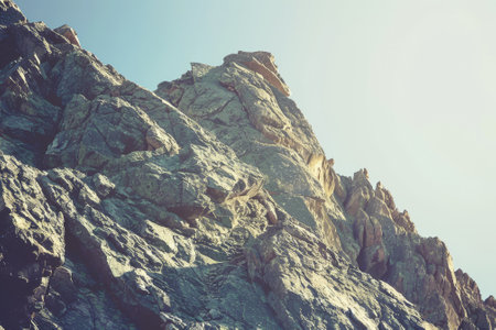 A rocky mountain with a clear blue sky in the background. The mountain is covered in rocks and he is very steepの素材