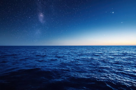 The ocean is calm and the sky is clear. The stars are shining brightly in the sky. The scene is peaceful and sereneの素材