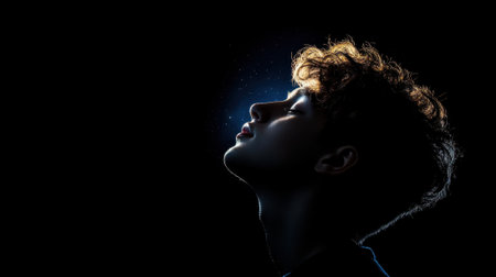 A man with brown hair is looking up at the camera. The image is in black and white and has a moody, mysterious feel to itの素材