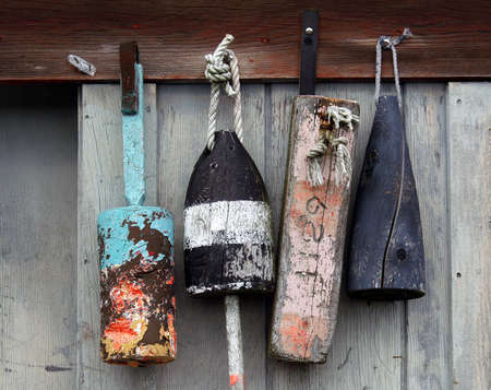          Lobster buoys on weathered gray wood fishing shack      の写真素材