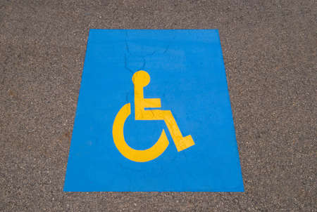 Handicap symbol painted on black asphalt parking lotの写真素材
