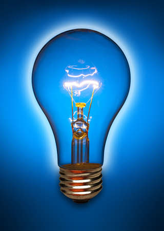 Clear light bulb back lit by a blue light and turned onの写真素材