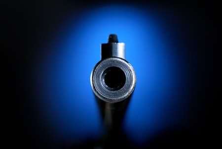 Gun barrel on blue pointing straight onの写真素材