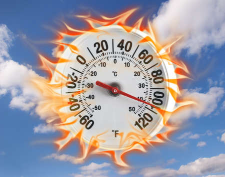 Thermometer on fire with a blue sky backgroundの写真素材