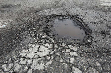 Pothole in road after spring thawの写真素材