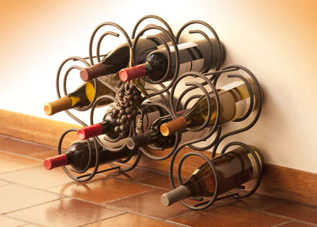 Red and white wine bottles stacked on iron rack shot with limited depth of field の写真素材