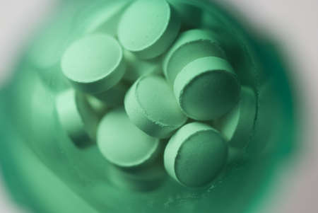 Macro view of pills shot in a green medicine bottleの写真素材