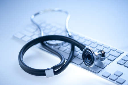 Medical stethoscope on a  computer keyboard in blue, closeup の写真素材