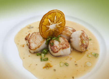 Grilled scallops in an orange sauceの写真素材