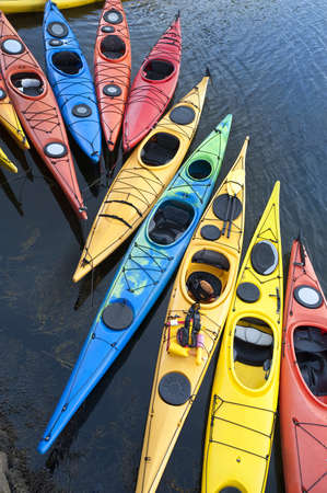Colorful fiberglass kayaks tethered to a dock as seen from aboveの写真素材