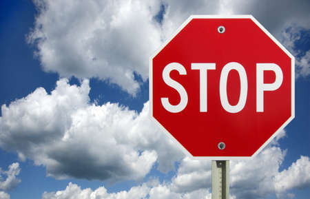 Stop sign against a dark cloudy sky with a clipping path for sign の写真素材