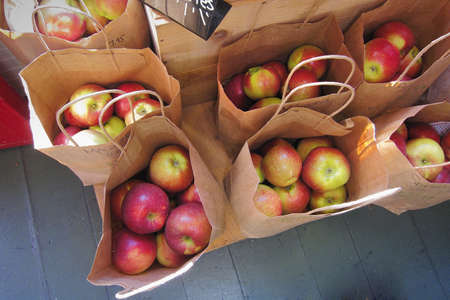 Apples in grocery paper bags ready to be picked up by customersの写真素材