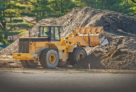 Front end loader moving piles of dirt on a construction siteの写真素材