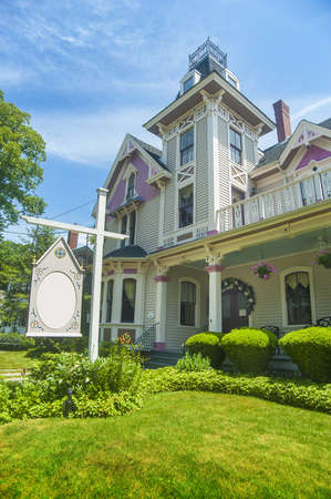 Bed and breakfast inn with gingerbread architecture and empty signの写真素材