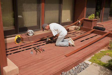 Senior repairing mahogany wooden deckの写真素材