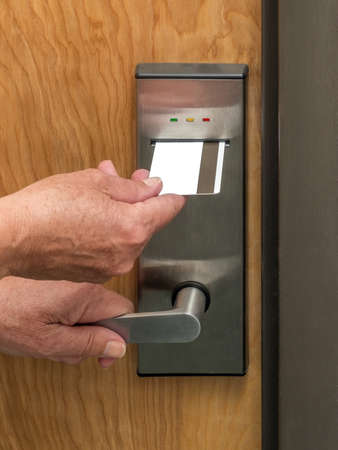 Hand inserting keycard in hotel room door lockの写真素材