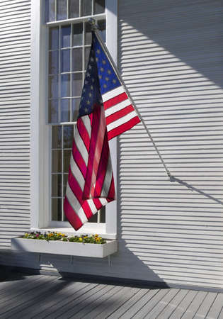 American flag against a tall windowの写真素材