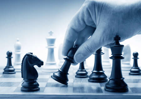 Hand moving a chess piece on boardの写真素材