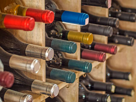 colorful wine bottles in wine rackの写真素材