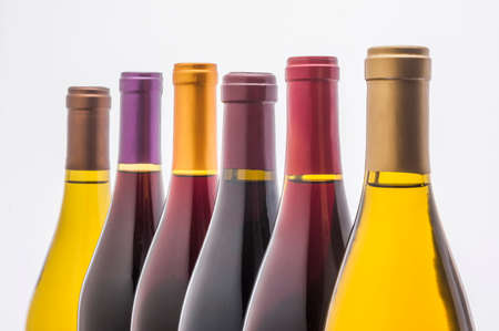 wine bottles in a row back lit on whiteの写真素材