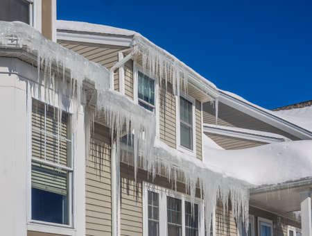 Ice dams and snow on roof and guttersの写真素材