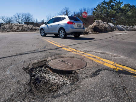 Big pothole caused by freezing and thawing during spring seasonの写真素材