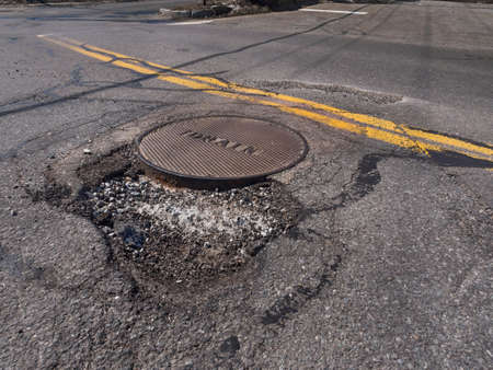 Big pothole caused by freezing and thawing during spring seasonの写真素材