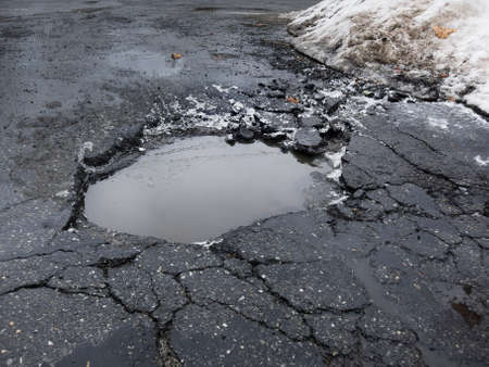 Big pothole caused by freezing and thawing during spring seasonの写真素材