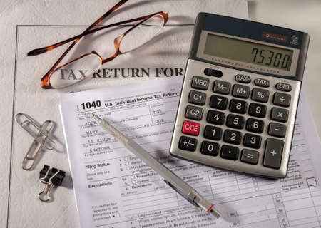 Tax accounting 1040 US Tax Form, with calculator, pen and glassesの写真素材