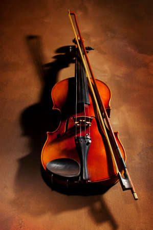 Vintage violin with shadow on old canvas backgroundの写真素材