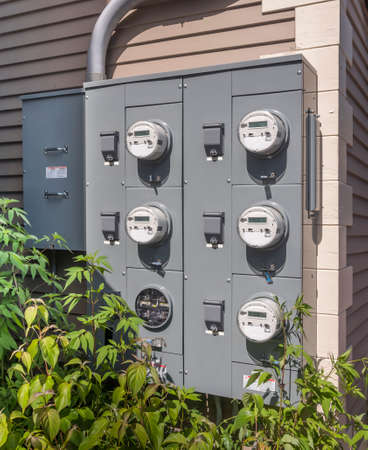 electricity usage meters on the side of a small mall