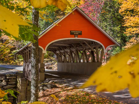 Red covered bridge in Fanconia New Hampshire during Fall seasonの写真素材