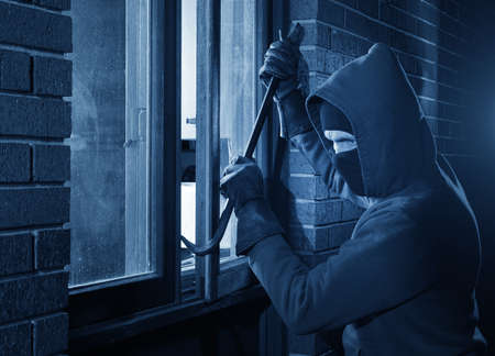 Hooded thief looking to break into a home
