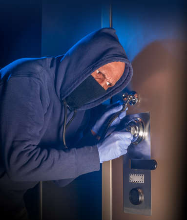 Safe cracker trying to open a big jeweler's safeの写真素材
