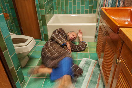 Senior man falling in a bathroomの写真素材