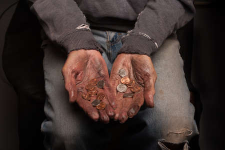 A homeless man looking at all the money he has in the worldの写真素材