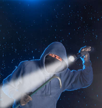 Intruder prowling on a rainy night looking to break into a house.の写真素材