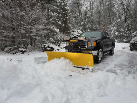 Truck snow plow clearing a parking lot after stormの写真素材