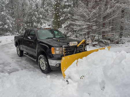 Truck snow plow clearing a parking lot after storm