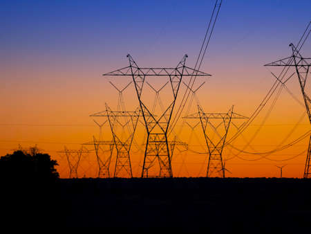 Silhouette High voltage electric towers at sunset time. High-voltage power lines. Electricity distribution stationの写真素材