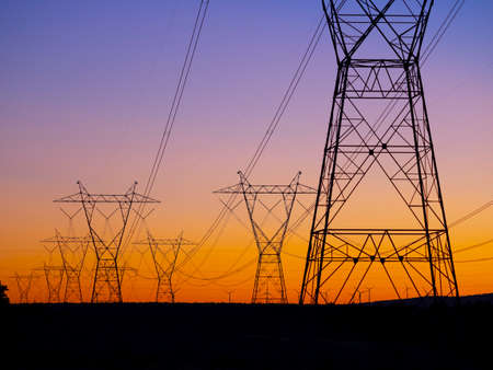 Silhouette High voltage electric towers at sunset time. High-voltage power lines. Electricity distribution stationの写真素材