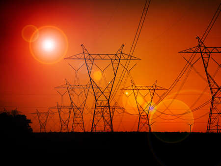 Silhouette High voltage electric towers at sunset time. High-voltage power lines. Electricity distribution stationの写真素材
