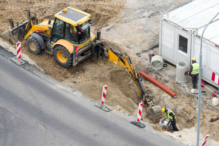 construction works in the street renovation carried out with the help of machines and peopleの写真素材