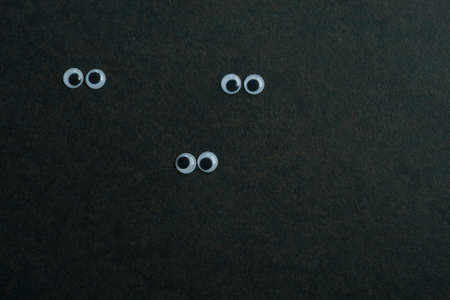 View of three pairs of eyes on a dark backgroundの写真素材