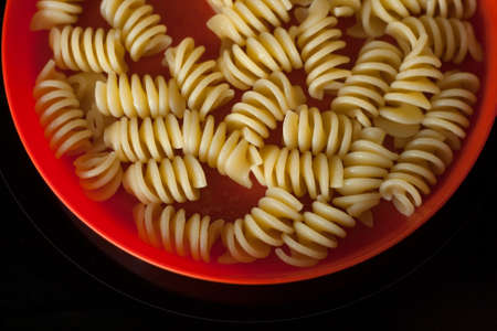Part of a bright plate with pasta on a black backgroundの写真素材