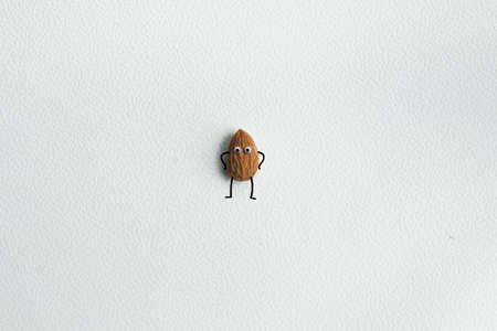 Almonds with eyes, hands and feet on a white background