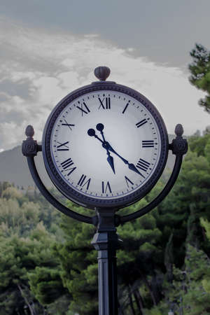 big clock in the park against the background of mountains on a summer day. close-upの写真素材