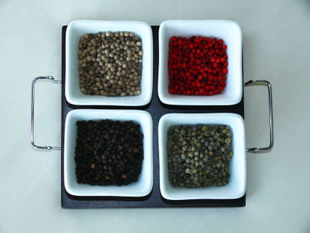 four kinds of spices in white bowls on white background