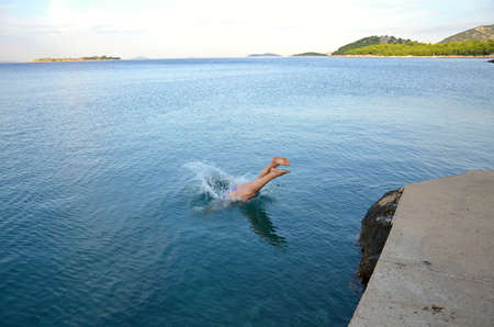 Man jumping into the Adriatic sea - Croatiaの写真素材