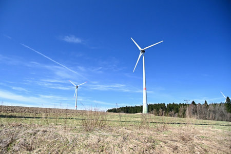 Wind turbines standing in a field, Ecological production of electricity - wind parks - power plantsの写真素材